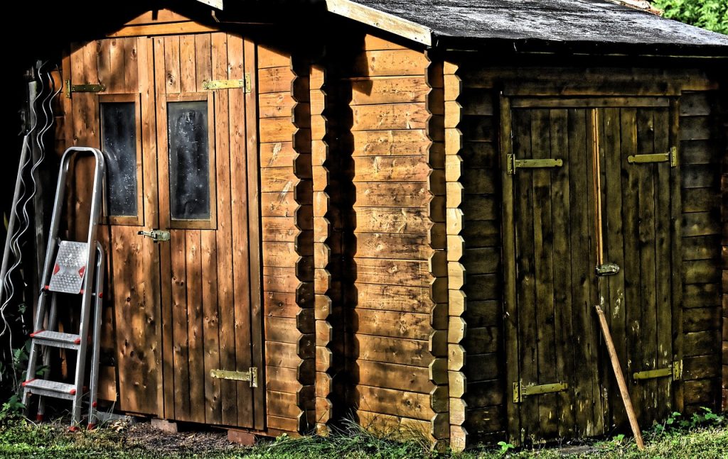 Wooden garden shed standing in a garden, the kind dismantled and rebuilt when moving house