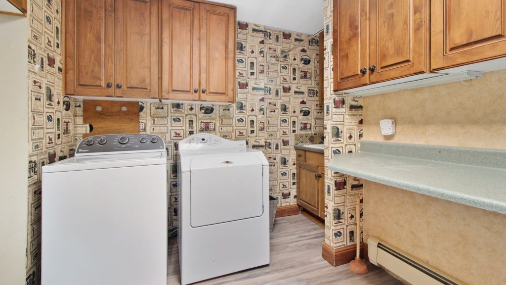 Kitchen utility area with wooden cabinets and appliances