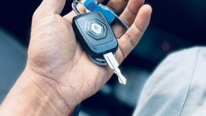 Hand holding car keys inside a vehicle, illustrating how to update the address on a V5C vehicle log book after moving
