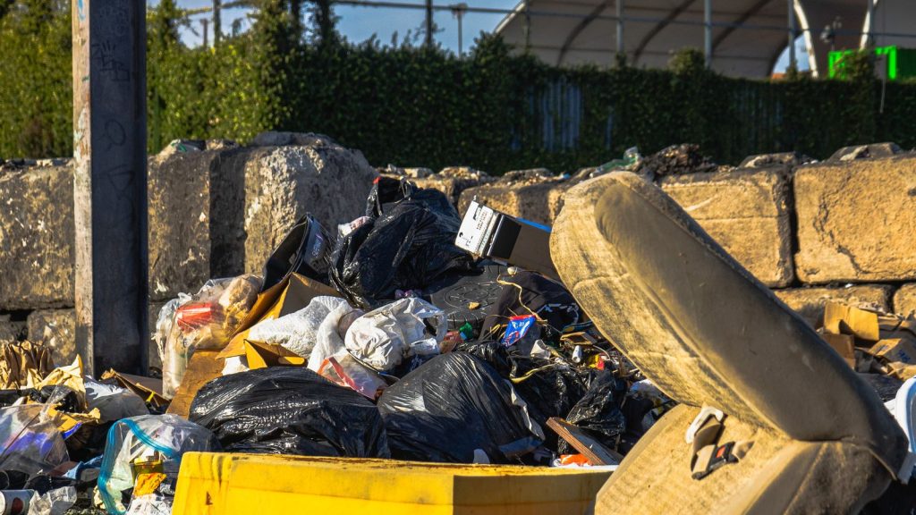 Old mattress discarded outdoors among other household waste, illustrating UK mattress disposal and fly-tipping