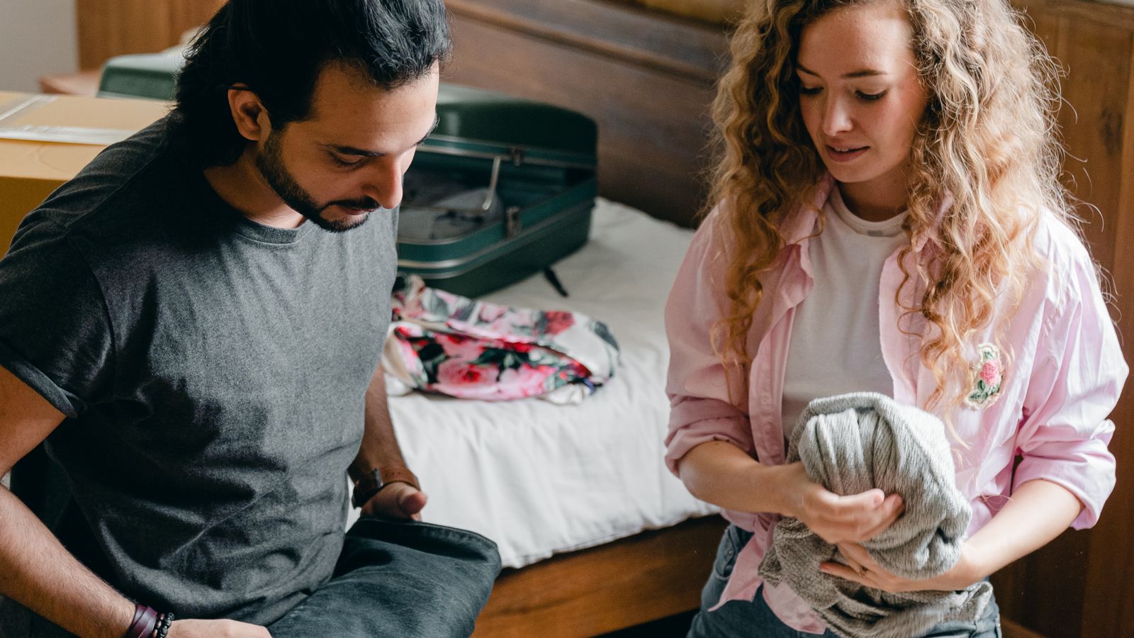 Couple unpacking cardboard boxes in an attic room