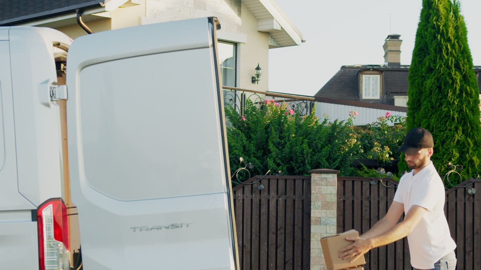 Van parked outside a house being loaded with boxes