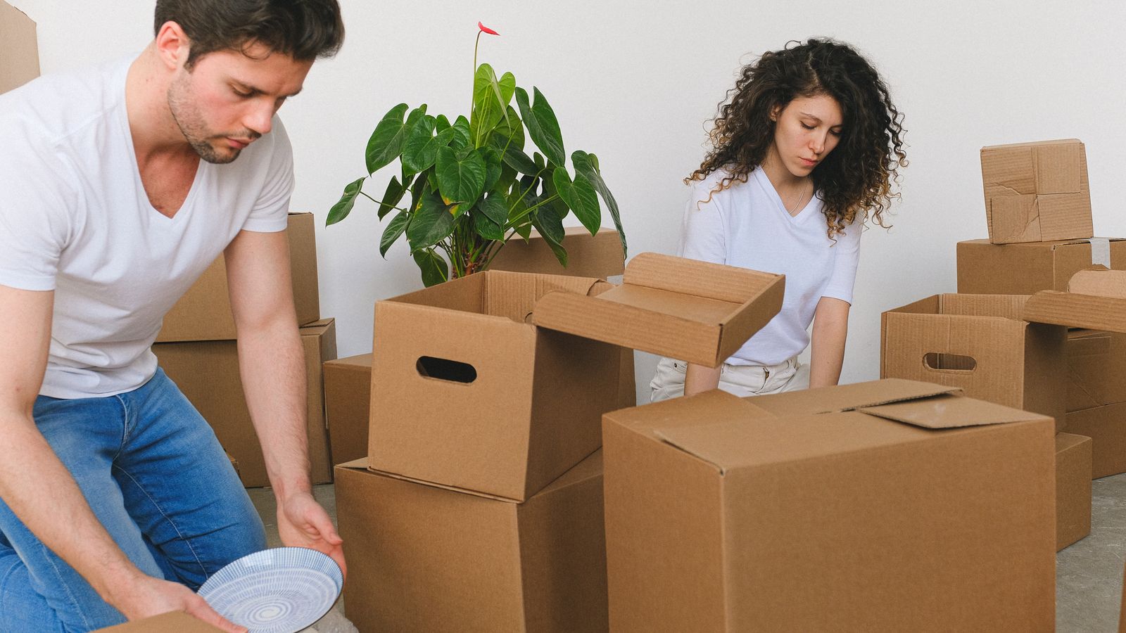 Couple wrapping fragile items into a box